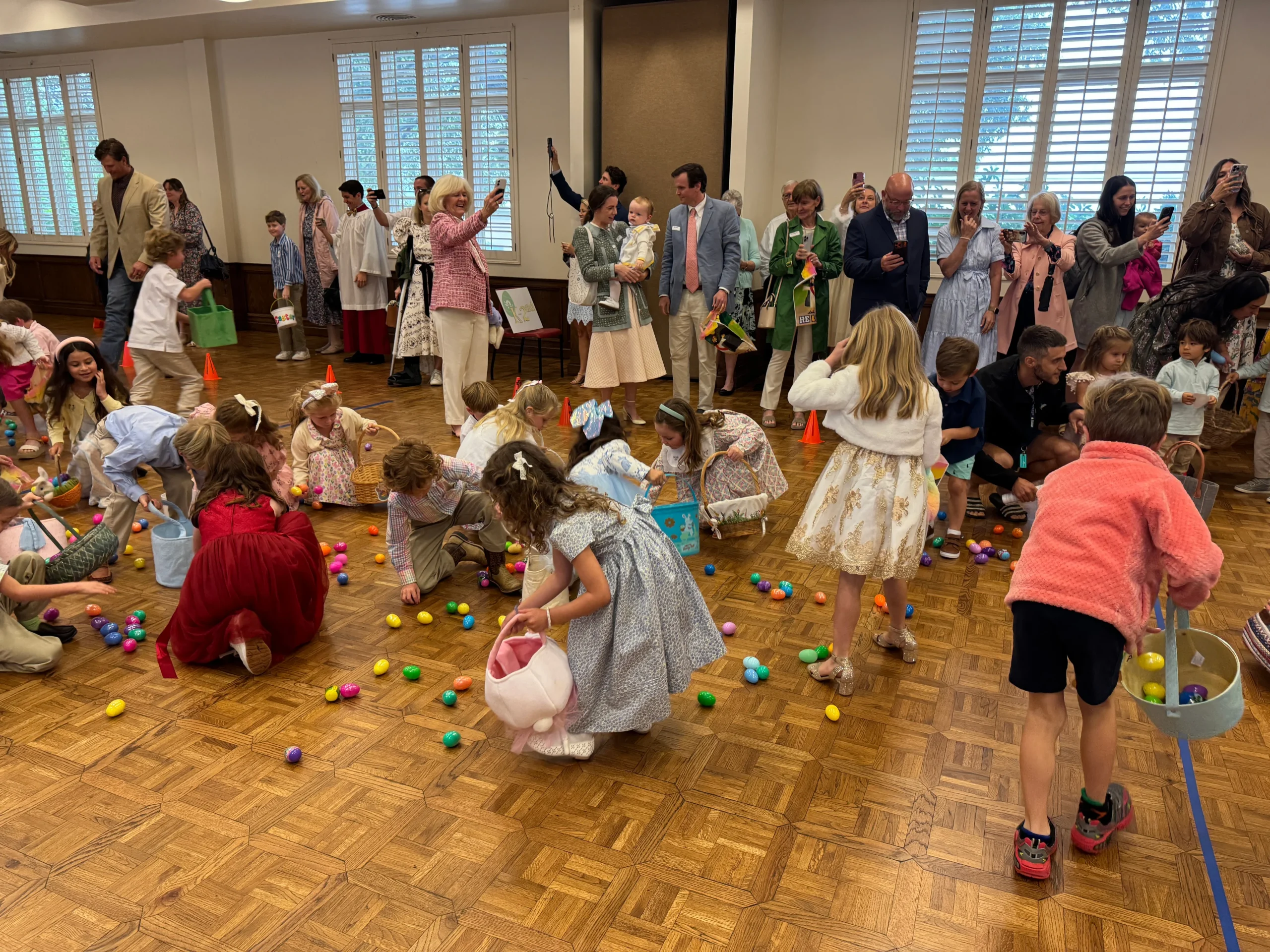 Children picking up easter eggs in a building