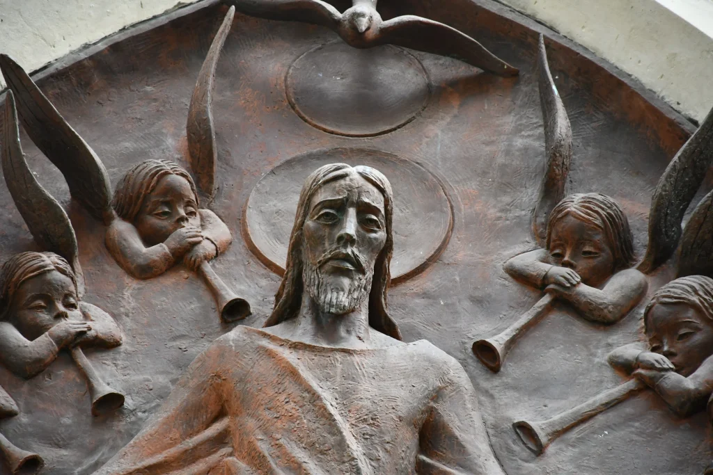 Stone Jesus statue with angels in the background