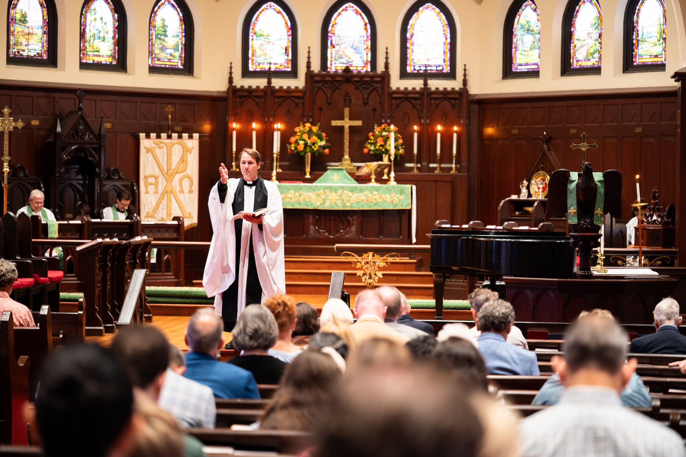 priest gesturing during church service